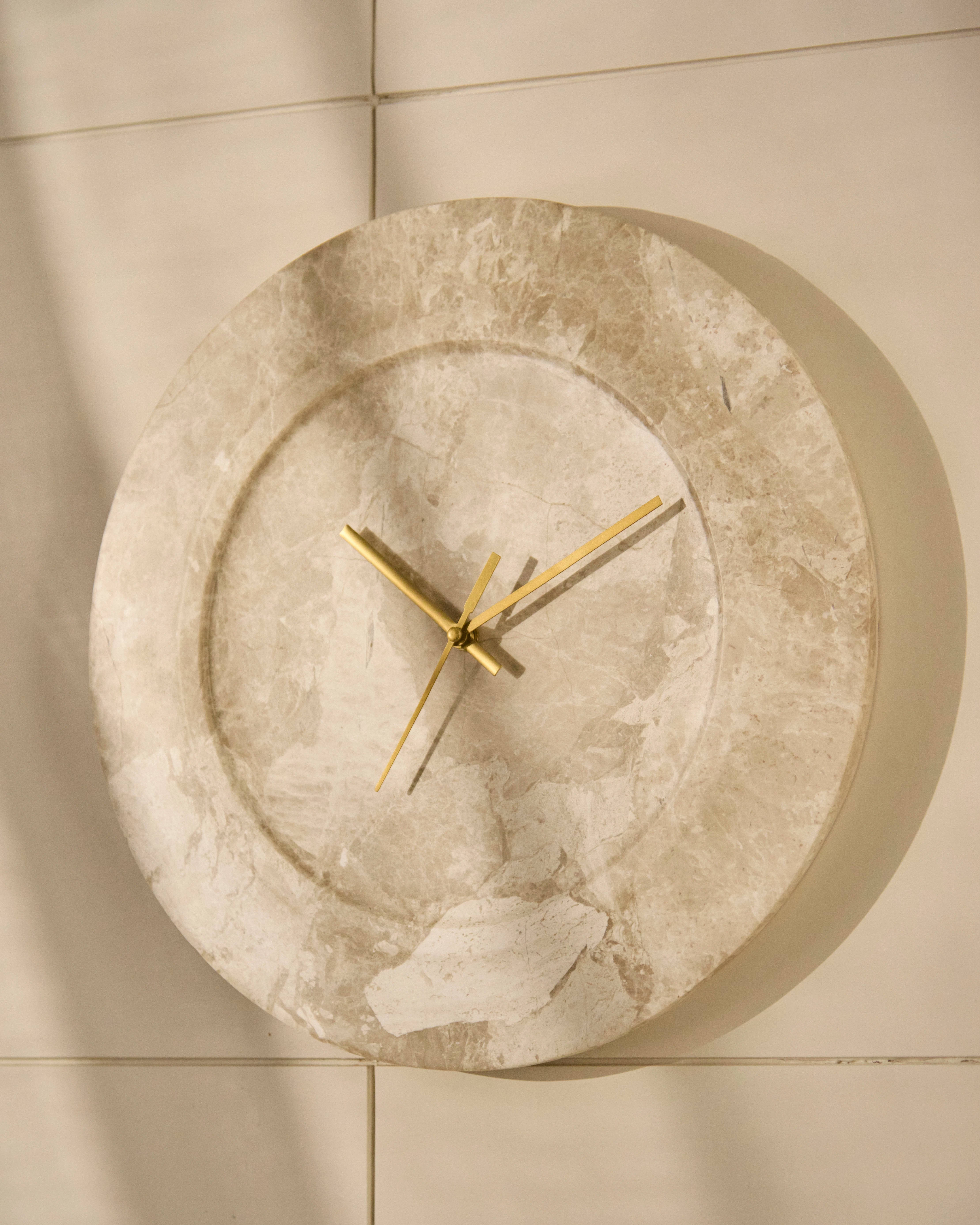Angled view of sculptural wall clock highlighting its fluid organic form and depth